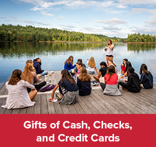 Students sitting on a dock. Gifts of Cash, Check, and Credit Cards